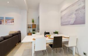 a dining room with a white table and a couch at Beach Town House in Vilassar de Mar