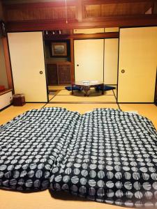 ein großes Bett in einem Zimmer mit Türen und einem Tisch in der Unterkunft Hakusan Japanese-Style House in Hakusan