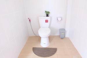 a bathroom with a toilet with a plant on the wall at Latisha House in Chiang Rai