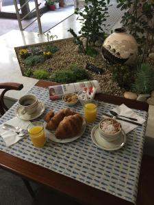 a table with a breakfast of food and orange juice at Hôtel Du Nord in Longwy