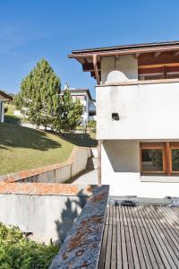 - deux vues sur une maison avec une terrasse en bois dans l'établissement Chesa Sarvit - Celerina, à Celerina