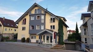 a yellow and white building on the side of a street at Hotel Pension Kaempfelbach in Königsbach-Stein