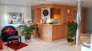 a kitchen with wooden cabinets and a counter top at Hotel Pension Kaempfelbach in Kämpfelbach