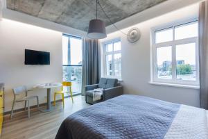 a bedroom with a bed and a chair and a table at 9010 Apartments in Vilnius