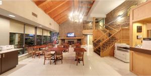 a dining room with tables and chairs and a staircase at Super 8 by Wyndham Sudbury ON in Sudbury