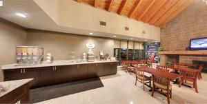 un restaurante con bar, mesas y sillas en Super 8 by Wyndham Sudbury ON, en Sudbury