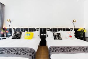 羅東鎮的住宿－時尚玩家-包棟民宿，两张带黑白枕头的床