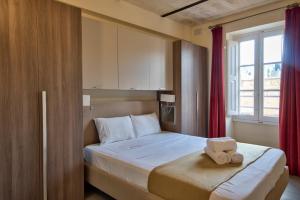 una camera da letto con un letto e un asciugamano sopra di Vallettastay Classic Apartments a La Valletta