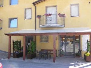 a yellow building with a table and a balcony at Albergo Le 2 Rose in San Severino Marche