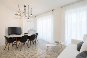 un soggiorno bianco con tavolo e sedie di La Promenade by Impero House a Stresa