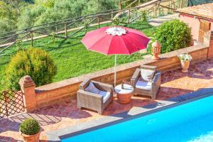 a patio with two chairs and an umbrella next to a pool at Angelica by PosarelliVillas in Molino Mazzetti