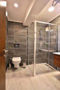 a bathroom with a toilet and a glass shower at Kule Hotel in Çanakkale