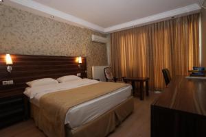 UnyeにあるYalihan Ari Hotelのベッドとデスクが備わるホテルルームです。