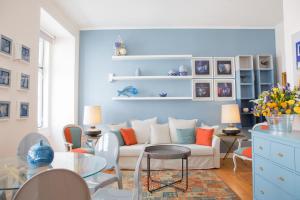 uma sala de estar com um sofá branco e uma parede azul em Rent4Rest - Lisbon Downtown Designer's Apartment em Lisboa