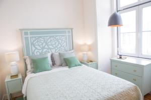 um quarto com uma cama branca e uma cabeceira azul em Rent4Rest - Lisbon Downtown Designer's Apartment em Lisboa
