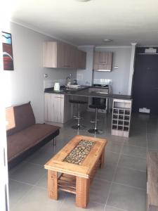 a kitchen with a couch and a table in a room at Apto Bahia Horizonte - La Herradura in Coquimbo