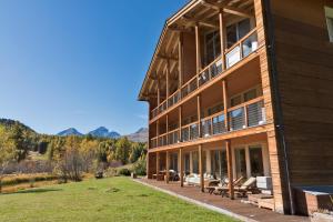 a large building with a porch and a lawn at Chesa Rivarel - Pontresina in Pontresina