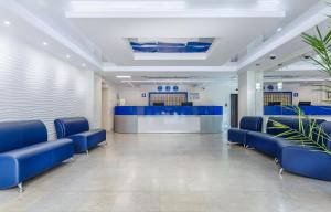 a waiting room at a hospital with blue chairs at Hotel Orbital in Obninsk