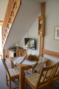 a dining room with a table with a bowl of fruit on it at APARTMAN "CHARDAK" in Bjelašnica