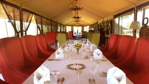 einen Tisch in einem Zug mit roten Stühlen und einem weißen Tisch in der Unterkunft Ole Serai Luxury Camp in Serengeti-Nationalpark