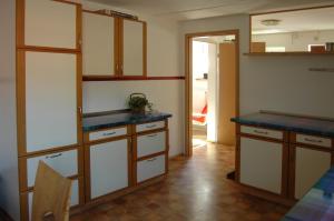 uma cozinha com armários brancos e bancadas azuis em Ferienwohnung Langenstadt em Neudrossenfeld
