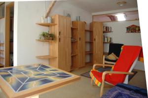 ein Wohnzimmer mit einem Tisch und einem roten Stuhl in der Unterkunft Ferienwohnung Langenstadt in Neudrossenfeld