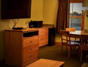 a hotel room with a dresser with a television on it at Champions Black Bear Lodge in Delhi