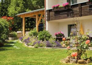 a garden of flowers in front of a house at Haus Carola in Bodenmais