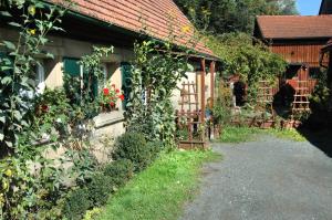 een huis met een poort en een tuin met rozen bij Ferienwohnung Langenstadt in Neudrossenfeld