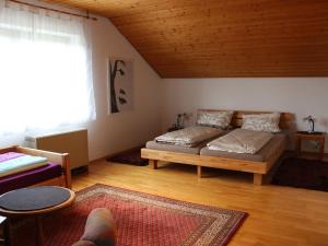ein Wohnzimmer mit einem Bett und einem Fenster in der Unterkunft Vronis Ferienwohnungen in Mühlingen