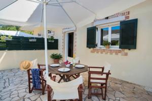 a patio with a table and chairs and an umbrella at Elias Appartments in Longós