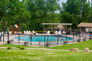 a swimming pool with chairs and people in it at Tamarack Wisconsin Dells, a Ramada by Wyndham in Wisconsin Dells