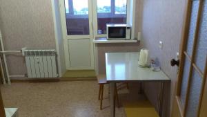 ヤロスラヴリにあるMoskovsky Prospect na Nyutonaのテーブルと電子レンジ付きの小さな部屋