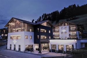 una casa grande con un blanco en Hotel La Fradora - Dolomites Hotel, en San Cassiano