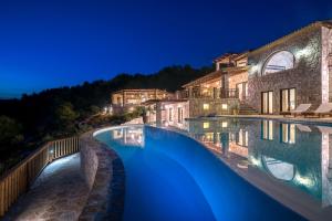 a swimming pool in front of a house at night at Amara Villa in Anafonítria