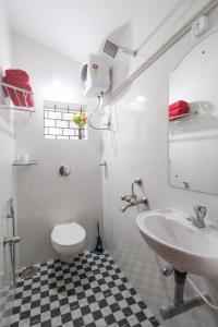 a white bathroom with a sink and a toilet at Hilias Retreat in Palolem