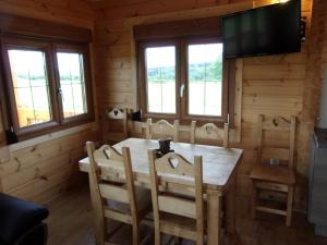 - une salle à manger avec une table, des chaises et des fenêtres dans l'établissement Chez Catherine et fanfan, à Rocroi