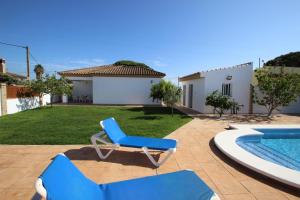 un sillón azul junto a la piscina en casa Garcia, en Conil de la Frontera