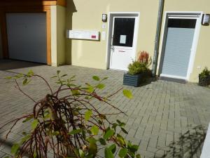 a house with a garage and a plant in front of it at City Apartment Jena in Jena