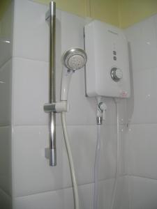 La salle de bains est pourvue d'une douche avec un pommeau de douche. dans l'établissement T.P. Place Hotel, à Phangnga