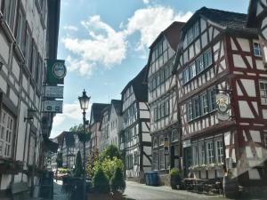 a city street with tall buildings and a clock at Hotel Holländischer Hof in Lich