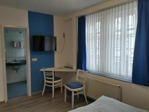 a room with a bed and a table and a window at Hotel Holländischer Hof in Lich