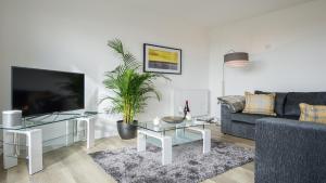 a living room with a couch and a tv at Tailored Stays - De Havilland House in Cambridge