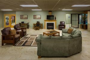 sala de estar con sofás, sillas y chimenea en Tamarack Wisconsin Dells, a Ramada by Wyndham en Wisconsin Dells