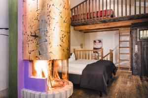 a bedroom with a fireplace in front of a bunk bed at Raffl's St. Antoner Hof in Sankt Anton am Arlberg