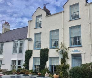 a large white house with blue windows at The Suites At Ty Anne in Beaumaris
