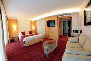 a hotel room with a bed and a couch at Le Churchill Hôtel & Spa in Carnac