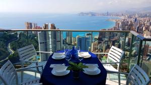 una mesa azul con sillas y vistas al océano en Highrise apartment with private terrace & sea views - 34th floor, en Benidorm