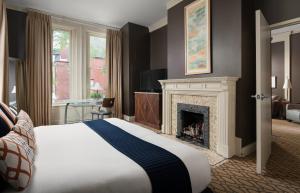 a hotel room with a bed and a fireplace at The Mansion on Delaware Avenue in Buffalo +38 photos