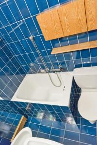 ツェエリーナにあるChesa Pradatsch Suot - Celerinaの青いタイル張りのバスルーム(トイレ、シンク付)